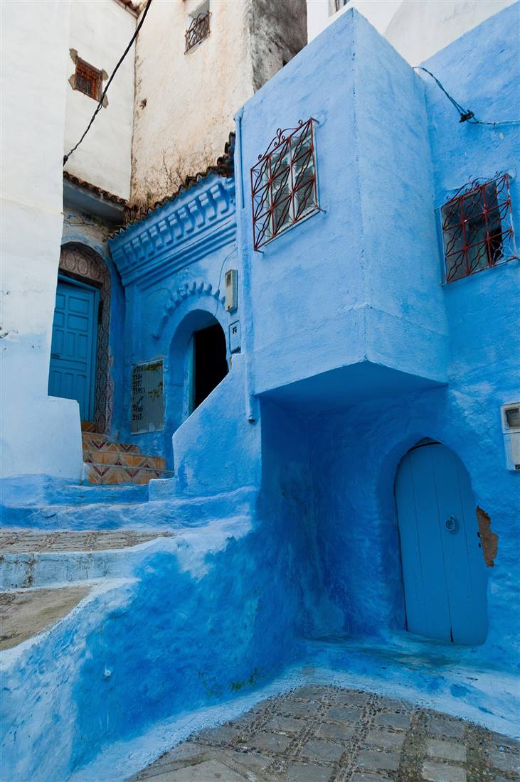 Blau getünchte Gasse mit blauer Tür in Chefchaouen